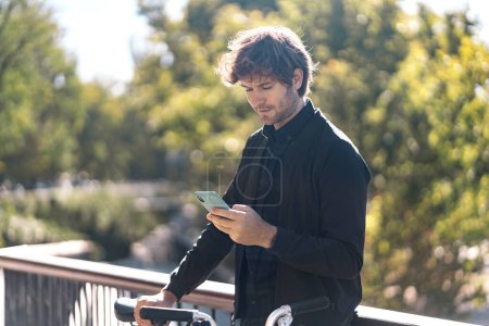 Téléchargez les photos : Photo d'un bel homme utilisant son téléphone portable dans la rue. - en image libre de droit
