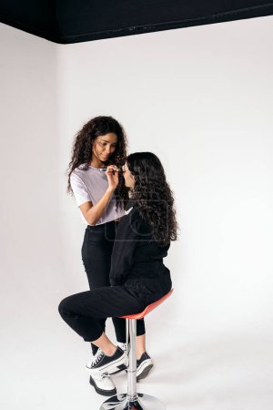 Photo for Stock photo of happy make up artist using brush to apply foundation to client. - Royalty Free Image