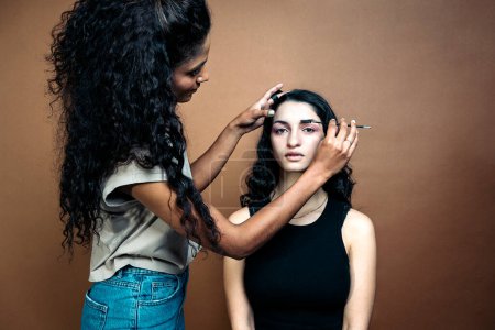 Photo for Stock photo of young model having her makeup done by professional artist in studio. - Royalty Free Image