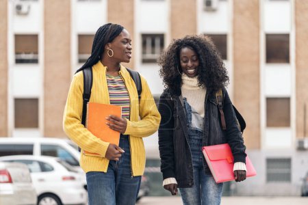 Téléchargez les photos : Stock photo of black students talking and laughing in the street. - en image libre de droit