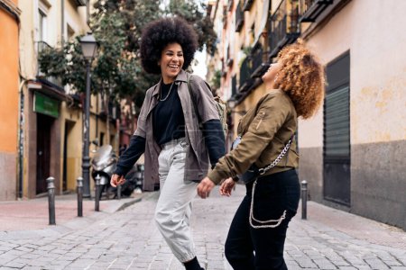 Photo for Stock photo of casual happy afro girls laughing and walking in the city. - Royalty Free Image