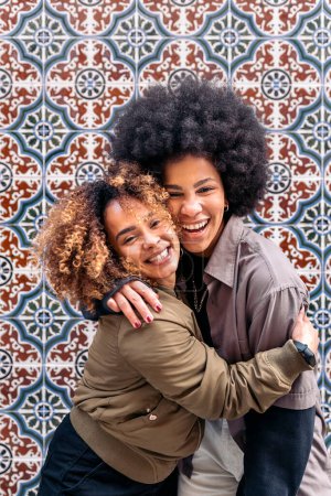 Foto de Stock photo of lovely afro girls hugging each other and looking at camera. - Imagen libre de derechos