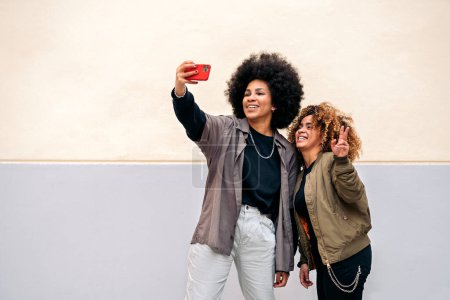Foto de Foto de stock de hermosos amigos afroamericanos tomando fotos con el teléfono. - Imagen libre de derechos