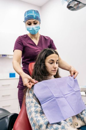 Téléchargez les photos : Stock photo of female dentist wearing face mask preparing girl for her checkup. - en image libre de droit