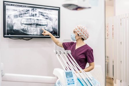 Téléchargez les photos : Stock photo of female dentist showing her young patient a x-ray. - en image libre de droit