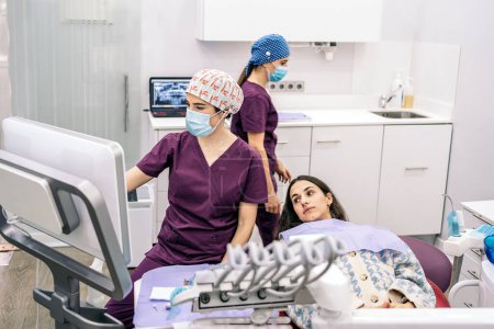 Foto de Foto de stock del equipo de trabajo femenino en la clínica dental que examina una radiografía. - Imagen libre de derechos