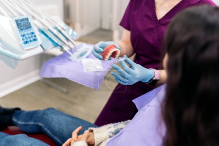 Téléchargez les photos : Photo de la dentiste qui travaille avec sa jeune patiente dans une clinique dentaire. - en image libre de droit