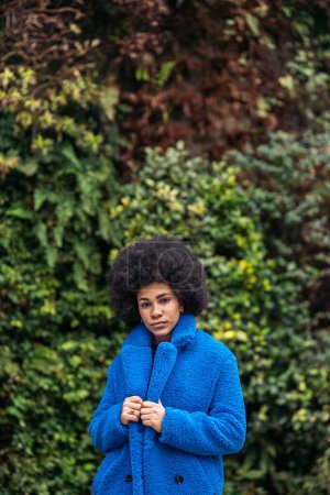Photo for Stock photo of young afro woman with expressive look against green background. - Royalty Free Image