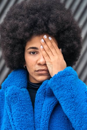 Photo for Stock photo of expressive african american covering her face with her hand and looking at camera. - Royalty Free Image