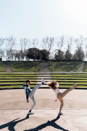 Téléchargez les photos : Photo de stock de fille heureuse et son ami pratiquant leurs mouvements de danse et s'amusant. - en image libre de droit