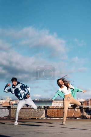 Téléchargez les photos : Photo de stock de fille cool et son ami pratiquant leurs mouvements de danse et s'amusant. - en image libre de droit