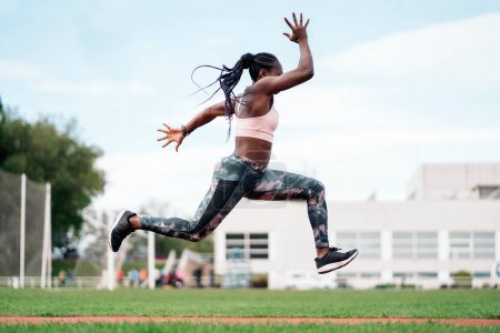 Photo for Stock photo of an African-American sprinter jumping in the sports center - Royalty Free Image