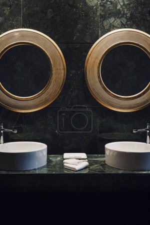 Foto de Interior image of double sink bathroom. Hotel bathroom with green tile walls and surfaces. Two mirrors, two sinks. Portrait orientation with copy space available - Imagen libre de derechos