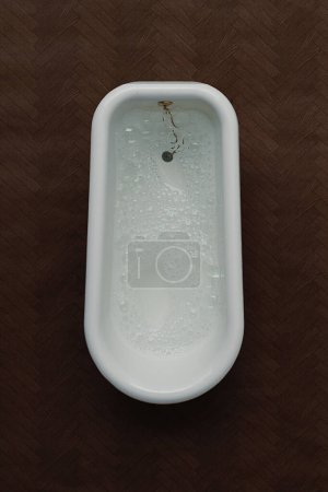 Photo for Traditional white bath shot from above with dark wood background. Portrait orientation with copy space - Royalty Free Image