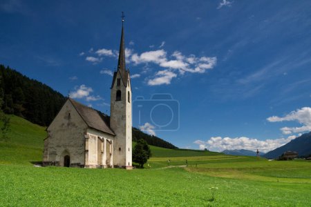 L'église Sainte-Madeleine près de Villabassa entourée d'un pré verdoyant dans les Dolomites italiennes