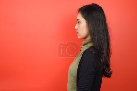 Foto de Lado vista de pie de hermosa mujer asiática aislado en rojo fondo - Imagen libre de derechos