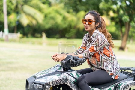 Téléchargez les photos : Get inspired by this young, fashion-forward woman who confidently rides an ATV while striking a fashionable pose. The perfect combination of style and power - en image libre de droit