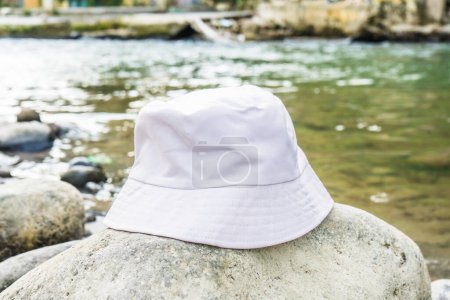 Con su diseño limpio y elegante, este sombrero de cubo blanco proporciona el accesorio perfecto para un día pasado cerca del río, blanco en blanco sombrero de cubo imagen de la maqueta