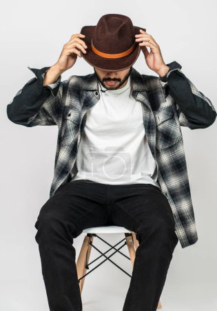 Foto de La maqueta muestra a un hombre con una camisa blanca y un sombrero de vaquero, arreglado con estilo con una pose simple, añadiendo encanto a sus imágenes - Imagen libre de derechos
