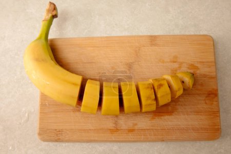 Gelbe Banane auf einem Küchentisch in Stücke geschnitten