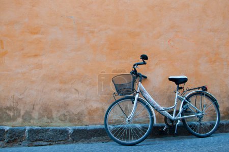 Foto de Bicycle with basket leaning against an orange wall. Orvieto, Italy - Imagen libre de derechos
