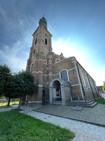 Foto de Hansbeke, Flandes Oriental, Bélgica 08 30 2022, Amplio ángulo de primer plano en la torre de la iglesia católica de estilo renacentista neo-flamenco desde la pasarela ... - Imagen libre de derechos