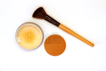 Photo for Close-up of crushed shimmer powder golden color with makeup and brush on white background - Royalty Free Image