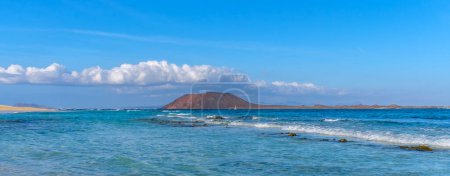 Foto de Panorama de la playa de Corralejo e isla de Lobos, agua azul y arena dorada y Canarias Fuerteventura, España. - Imagen libre de derechos