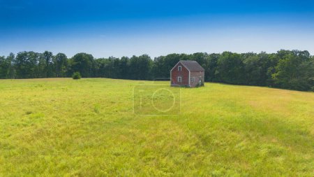 Photo for A vertical shot of a green field with lonely house - Royalty Free Image