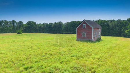 Foto de Un tiro vertical de un campo verde con casa solitaria - Imagen libre de derechos