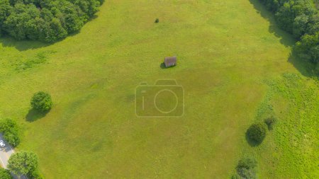 Photo for A vertical shot of a green field with lonely house - Royalty Free Image