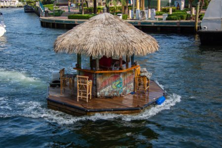Photo for Ft. Lauderdale, Florida - February 2, 2023: Floating tiki bar cruises down the Intracoastal Waterway in Fort Lauderdale, Florida, USA. - Royalty Free Image