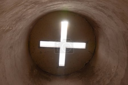 Téléchargez les photos : Une croix dans l'obscurité avec une lumière qui la traverse - en image libre de droit
