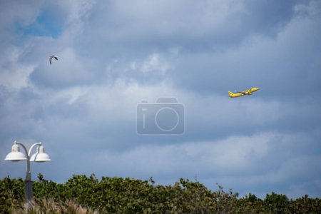 Téléchargez les photos : Miami, USA : avion jaune dans le ciel nuageux - en image libre de droit