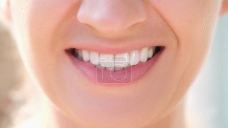 Gros plan de la femme souriante heureuse avec des dents blanches parfaites. Blanchiment des dents, soins dentaires et stomatologie concept