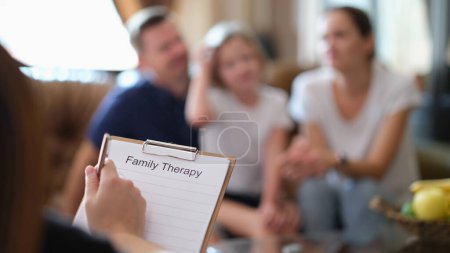Téléchargez les photos : Gros plan du psychologue lors d'une séance de psychothérapie avec sa famille au bureau. Psychologie et thérapie familiale concept - en image libre de droit