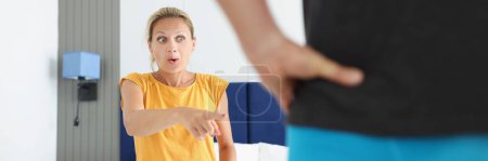 Photo for Shocked woman pointing finger at man in shorts. Intimate life and sex in relationships concept - Royalty Free Image