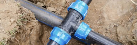 Photo for Installed PVC water pipes in trench at construction site. Plumbing system outside the house concept - Royalty Free Image