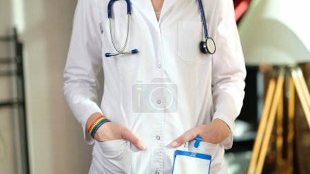 Woman doctor with lgbt bracelet on her hand. Gay nurse or doctor and transgender medical support.