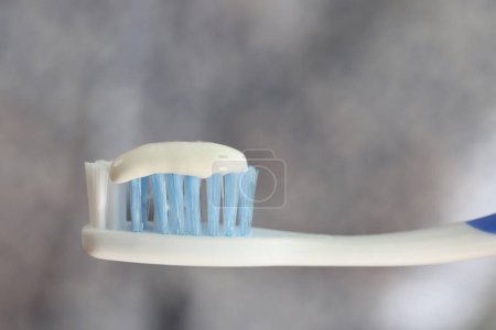 Téléchargez les photos : Toothbrush and toothpaste close up on gray blurred background. Dental care and hygiene concept. - en image libre de droit