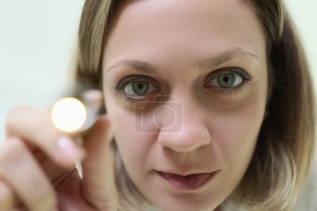 Foto de Una cara cercana de una joven con una linterna. Diagnóstico médico, estudio oftalmológico - Imagen libre de derechos