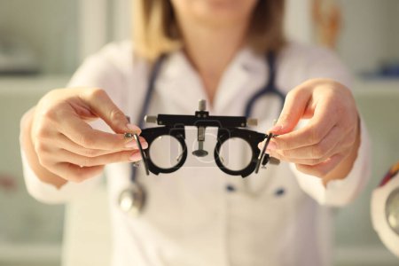 Foto de El optometrista sostiene un marco para la selección de lentes, un primer plano. Estudio oftalmológico, astigmatismo - Imagen libre de derechos