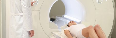 Im medizinischen Labor kontrolliert der männliche Radiologe MRT oder CT mit der Patientin. Hightech modernes medizinisches Gerätekonzept
