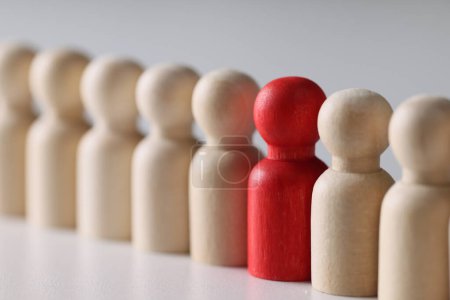 Foto de Figura roja en fila de muchas figuras comunes de personas de madera. Individualidad, concepto único y diferencia. - Imagen libre de derechos