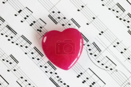 Photo for Red heart on paper with musical notes close up. Concept of romantic music and love songs. - Royalty Free Image