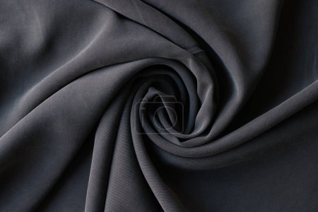 Foto de Tejido gris oscuro laminado hecho de algodón vista superior. Muestra de material de costura en tienda textil. Paño suave para servicio de confección en atelier - Imagen libre de derechos