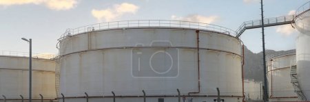 Portrait of white petrochemical storage tanks or tank farm. Crude oil export factory industry or fuel storage