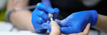 Photo for Close-up of nail specialist doing manicure to client using special apparatus, hardware manicure. Beauty day and manicurist concept - Royalty Free Image
