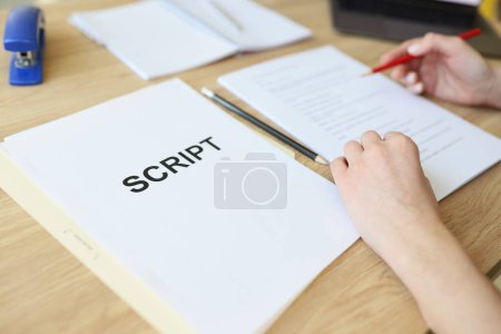 Photo for Attentive woman reads movie script papers editing text with pencil. Assistant sits at wooden table making edits for harmonious role in film - Royalty Free Image