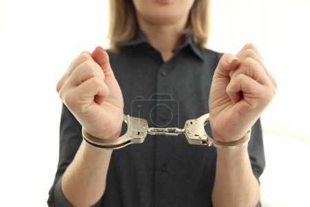 Photo for Female person with metal handcuffs in prison cell. Arrest of criminal for judgement in state court. Restoration of justice in state - Royalty Free Image